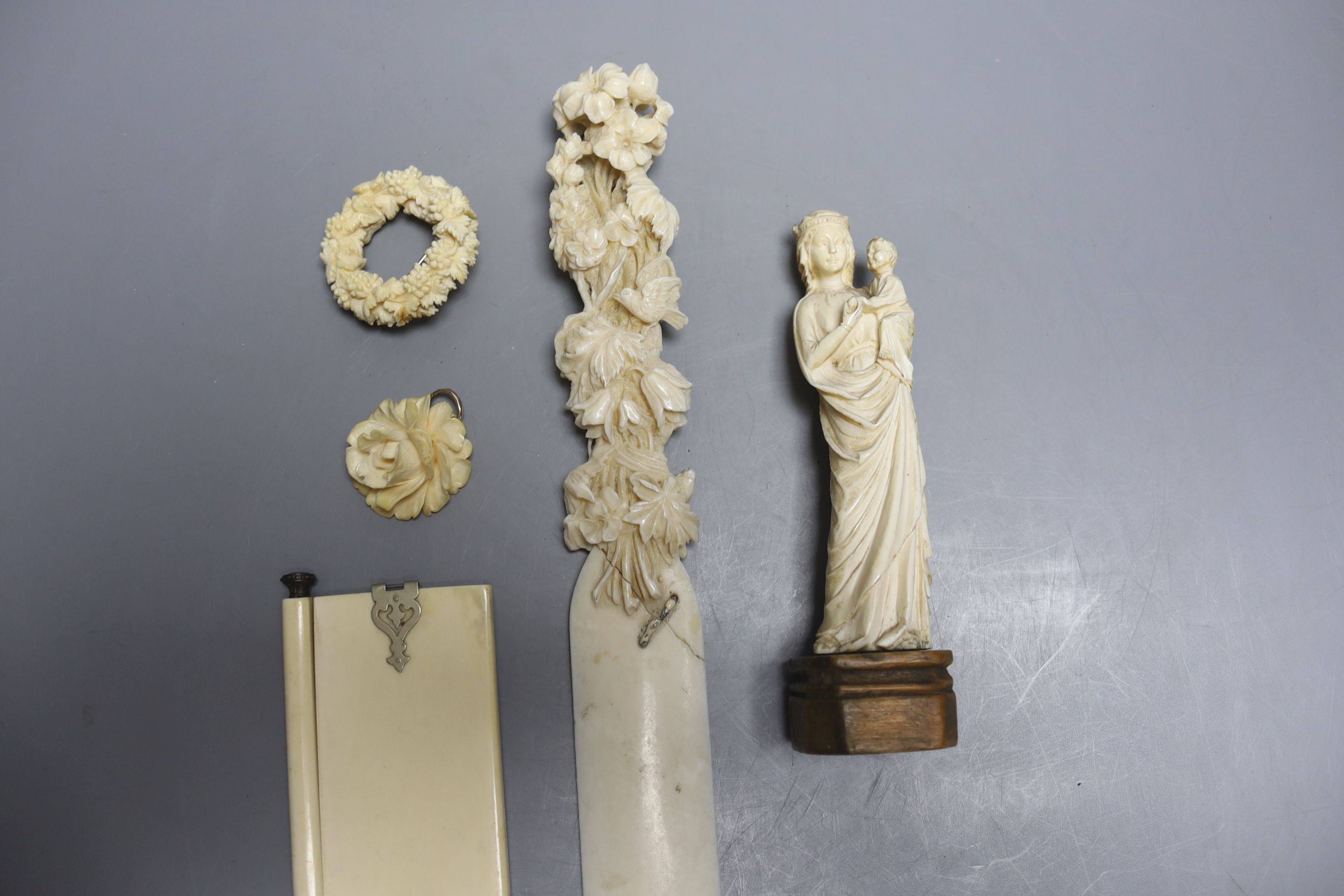 A 19th century carved ivory Madonna child, an ivory figural carving, a pendant, a brooch, a page turner and a diary